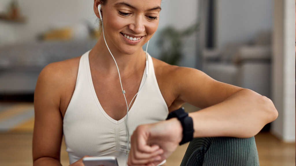 Mulher usando smart watch para ajudar no seu treino.