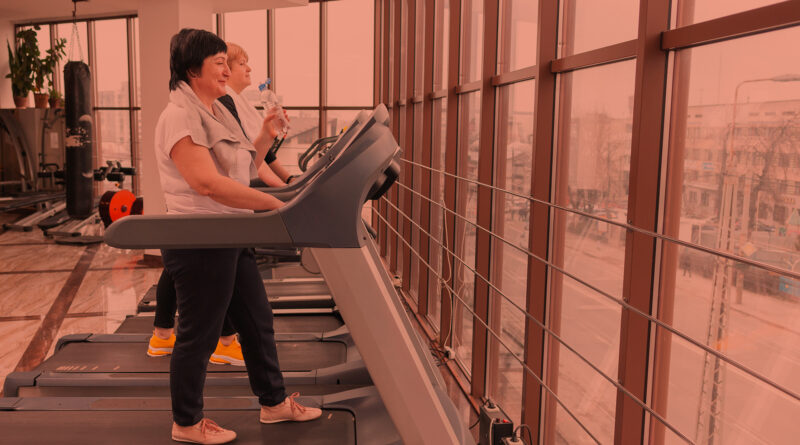 Mulher na terceira idade treinando na academia durante o inverno