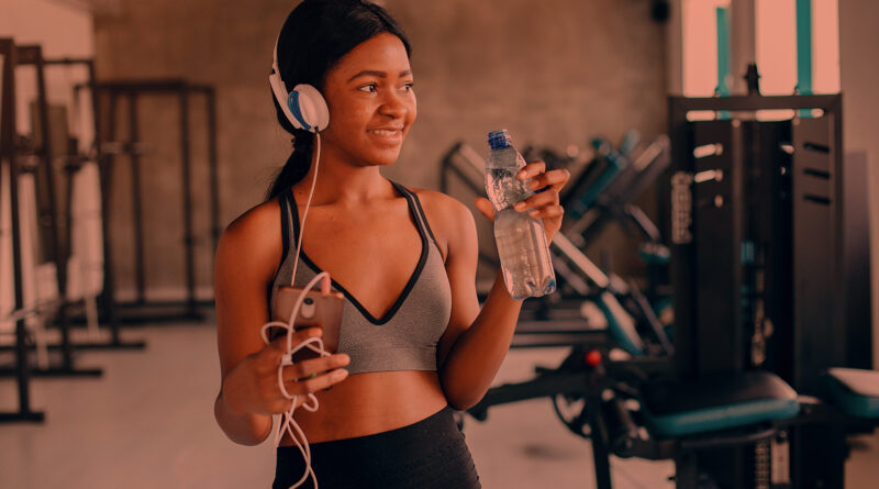 Mulher jovem chegando na academia para fazer seu treino de musculação.