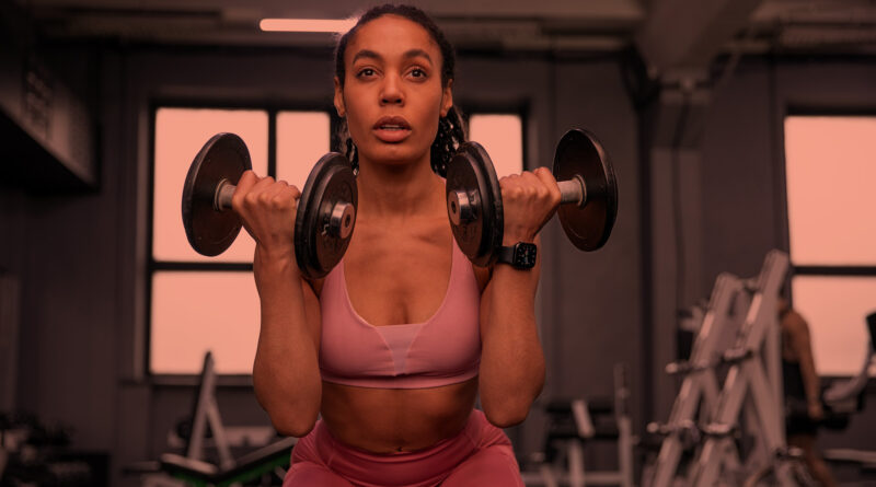 Mulher em treino de musculação para queimar calorias.