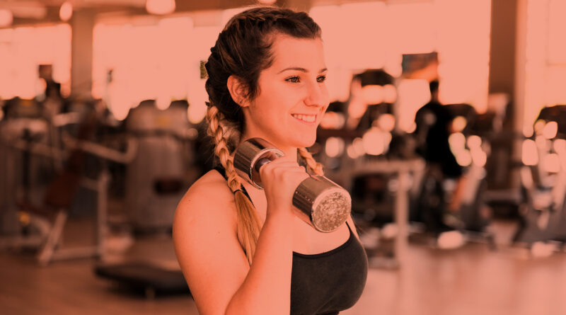 Mulher treinando com halteres na academia.