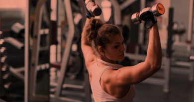 Mulher treinando braços na academia de musculação.