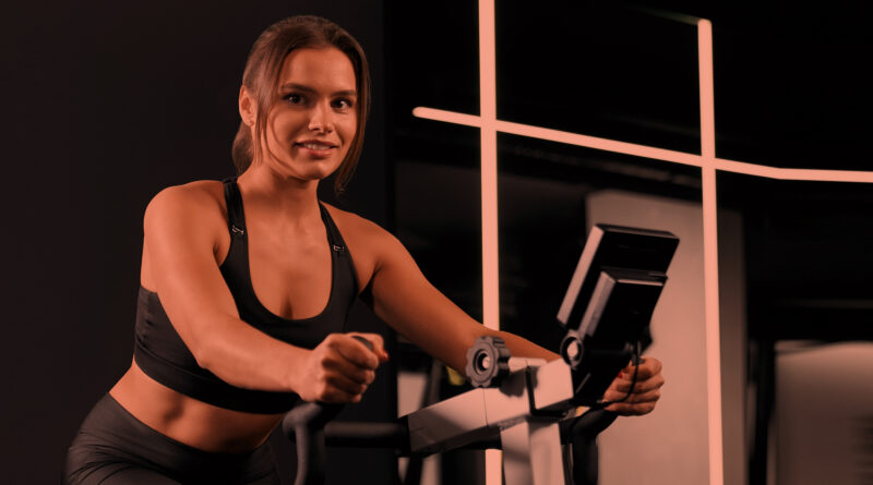 Mulher em treino aeróbico na academia.