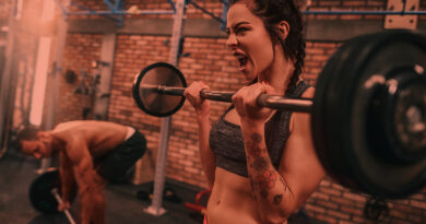 Mulher levantando barras na academia de musculação
