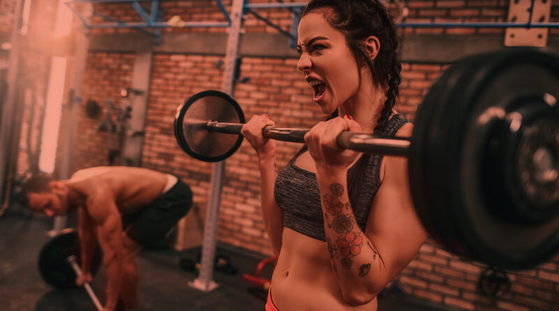 Mulher levantando barras na academia de musculação