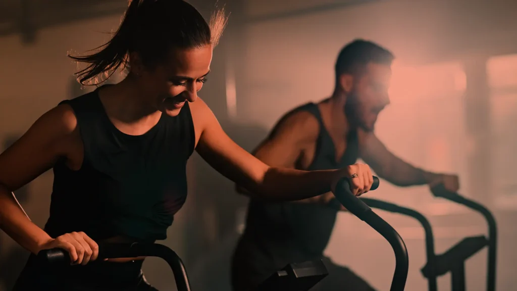 Mulher e homem jovens em treino na academia.