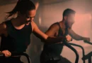 Mulher e homem jovens em treino na academia.
