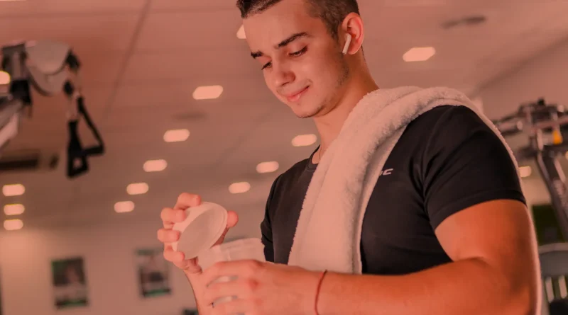 Jovem preparando shake de suplementos para treinar.